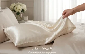«روبالشتی ساتن براق روی تخت برای بررسی لطافت و انتخاب بهترین پارچه روبالشتی»