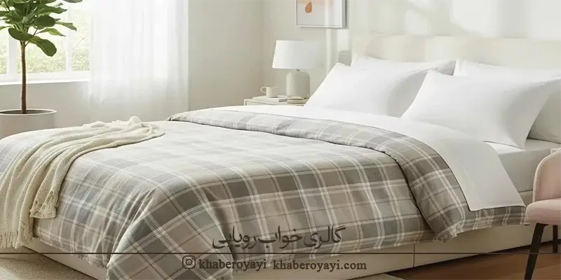 «کاور لحاف دو نفره طرح چهارخانه خاکستری روشن روی تخت در اتاقی با نور طبیعی و دکور ساده»