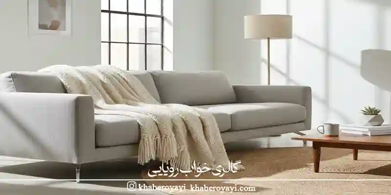 شال مبل بافت ریز کرم روی مبل طوسی روشن به‌عنوان نمونه‌ای از بهترین جنس شال مبل برای سبک‌های مدرن و مینیمال.